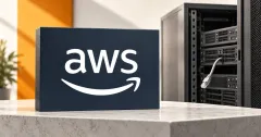 Large official white AWS wordmark and smile arrow on a navy stone sign beside an unbranded greyscale server cabinet with a disconnected network cable, on an off-white desk with an orange background panel.