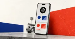 Greyscale smartphone showing abstract prediction-market cards beside a football and stadium lights on cobalt blue, coral and off-white editorial panels.