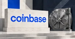 Large official blue lowercase Coinbase wordmark on an off-white limestone sign beside an unbranded greyscale steel vault door with two keyholes, against cobalt and slate panels.