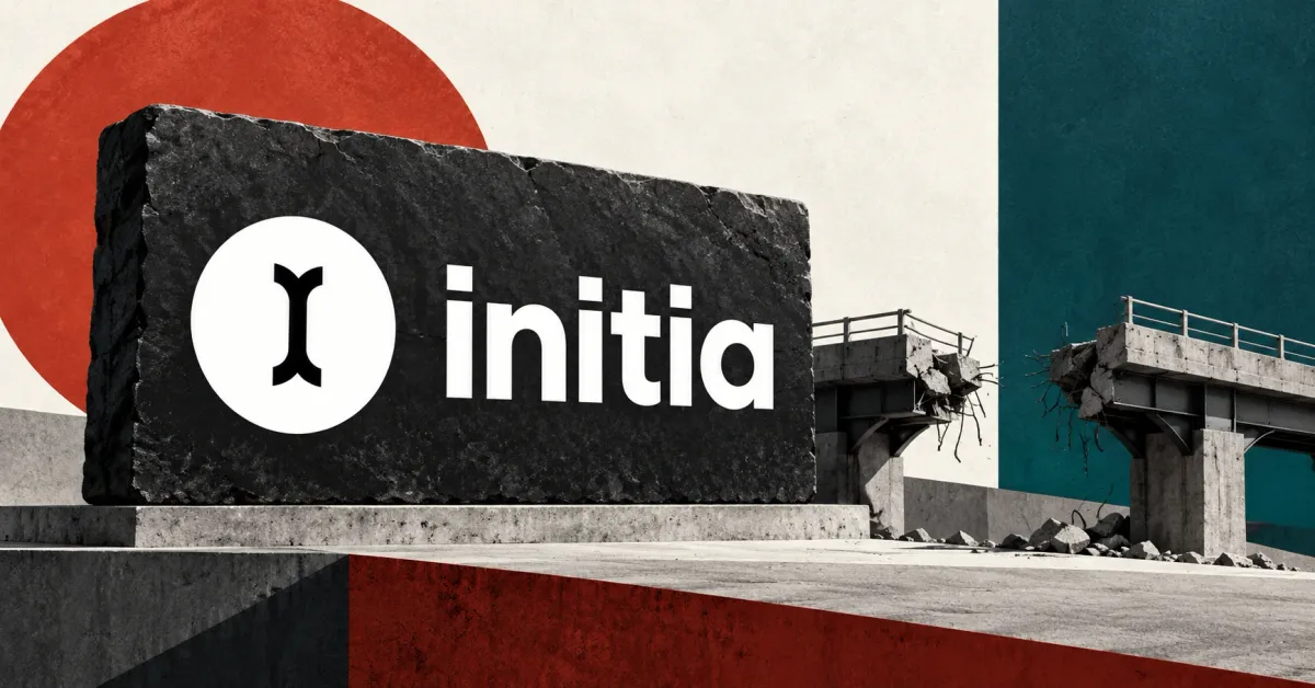 One large official white Initia icon and lowercase wordmark on a charcoal stone sign beside an unbranded greyscale broken bridge, against off-white, rust-red and deep-petrol panels.