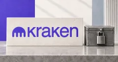 Large official purple Kraken emblem and wordmark on an off-white desk sign beside an unbranded greyscale locked metal collateral box.