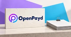 Large official purple-blue OpenPayd emblem and navy OpenPayd wordmark on an off-white stone sign beside an unbranded greyscale stack of blank financial papers and a binder clip, against lavender and cyan editorial panels.