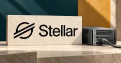 One prominent official black Stellar symbol and wordmark on an ivory stone sign beside an unbranded greyscale server with a cable, against petrol and ochre panels.
