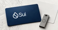 Large official white Sui wordmark and droplet on a navy security card beside a greyscale unbranded hardware security key and blank recovery card.